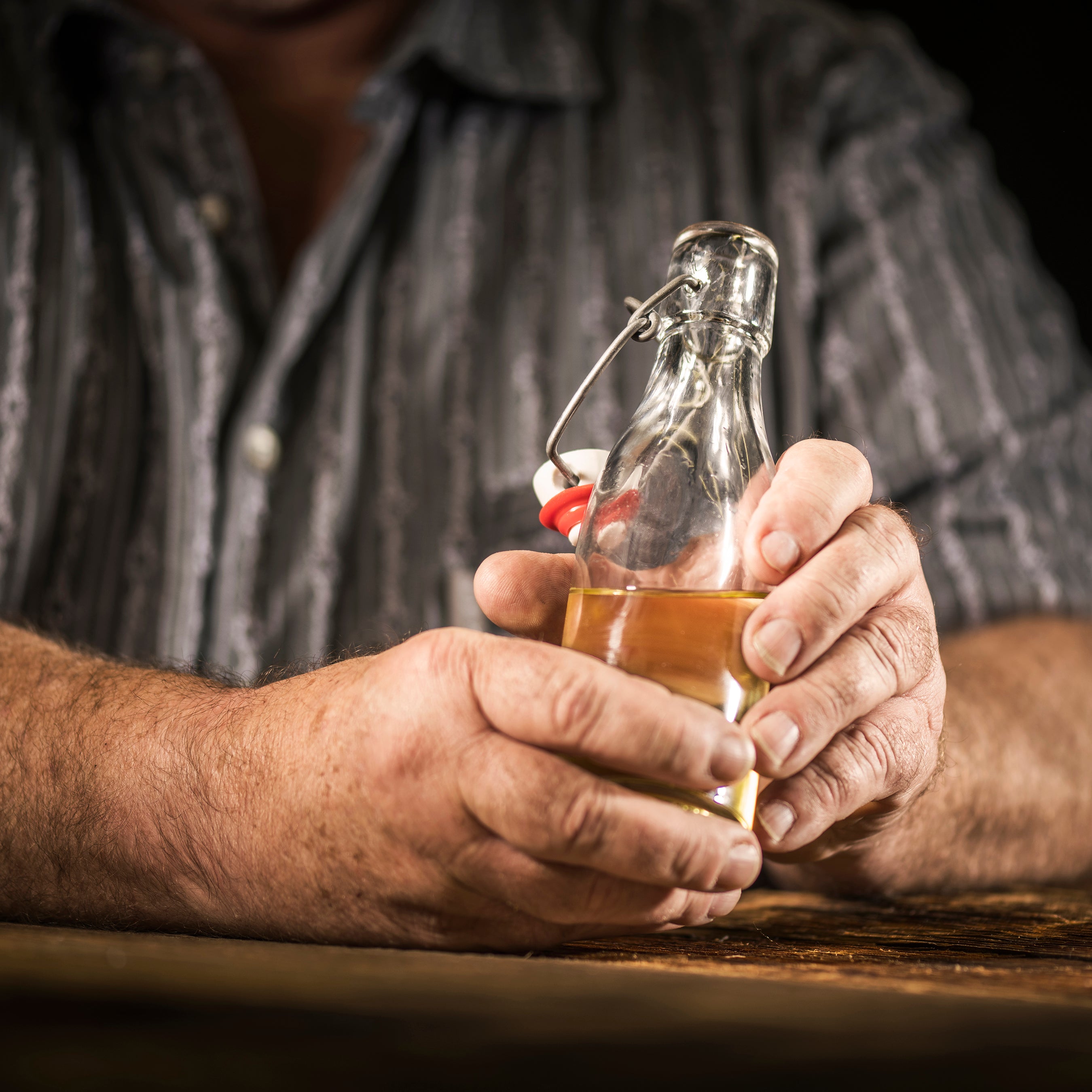 Hände halten eine Flasche mit reinem Murmeliteröl