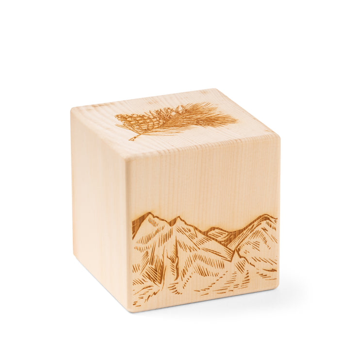 Cube parfumé en bois de pin suisse orné d'une gravure de montagne et d'une branche de pin suisse sur le dessus.