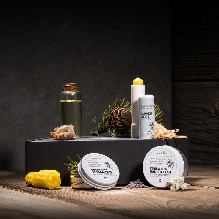 Puralpina Edelweiss Set mit Handbalsam, Fussbalsam und Lippenstift auf Holzuntergrund