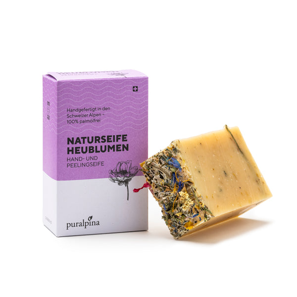 Puralpina Naturseife Heublumen mit violetter Kartonverpackung und Seifenstück mit Heublumen